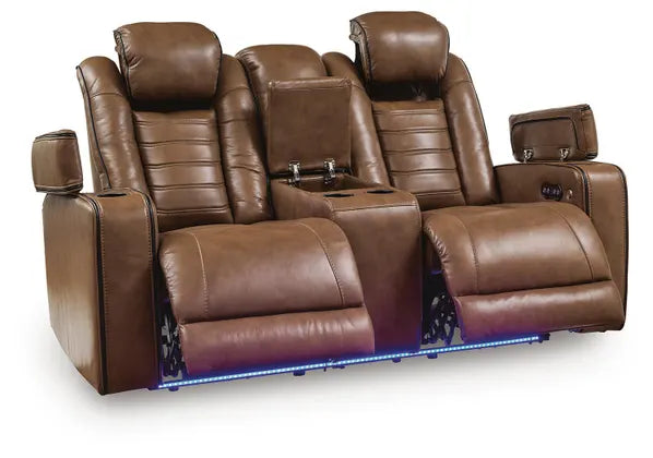 Ashley Gruaro Brown Power Reclining Loveseat (PCU1420018) with extended footrests, open storage compartments, center console, cup holders, and blue LED base lighting.