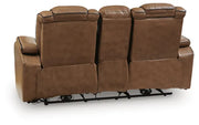 Rear view of Ashley Gruaro Brown Power Reclining Loveseat (PCU1420018), showing its upholstered back panels, padded headrests, center console structure, and exposed metal reclining mechanism beneath the loveseat.